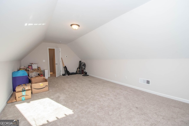 additional living space with visible vents, baseboards, lofted ceiling, and carpet floors