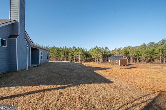 view of yard featuring a storage shed and an outbuilding