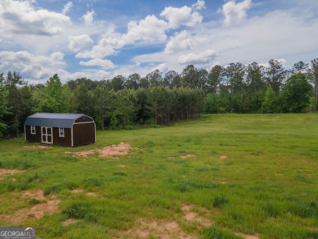 296 Beavers Rd, Grantville, GA 30220 - view of grassy yard with a storage unit, an outdoor structure, and a forest view