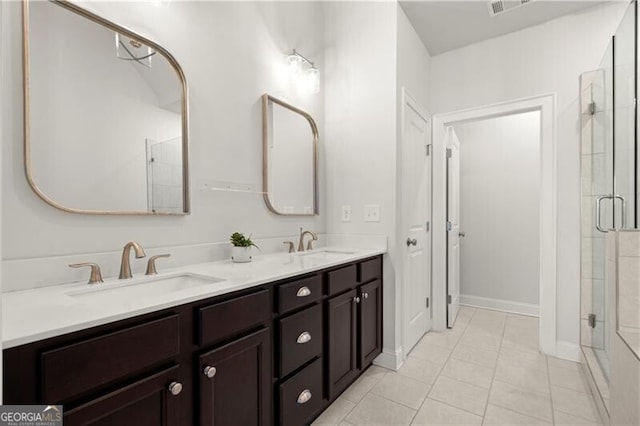 full bathroom featuring double vanity, a shower stall, and a sink