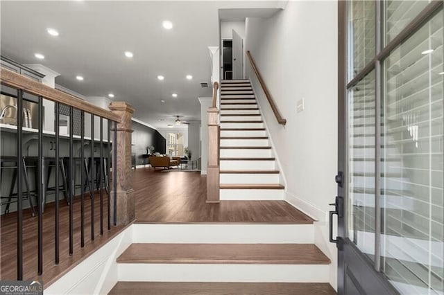 stairs with recessed lighting, wood finished floors, and ornamental molding