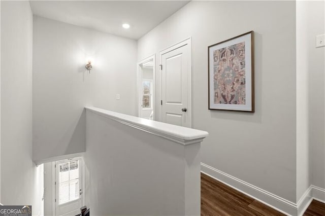 hall featuring plenty of natural light, visible vents, baseboards, and dark wood-style flooring