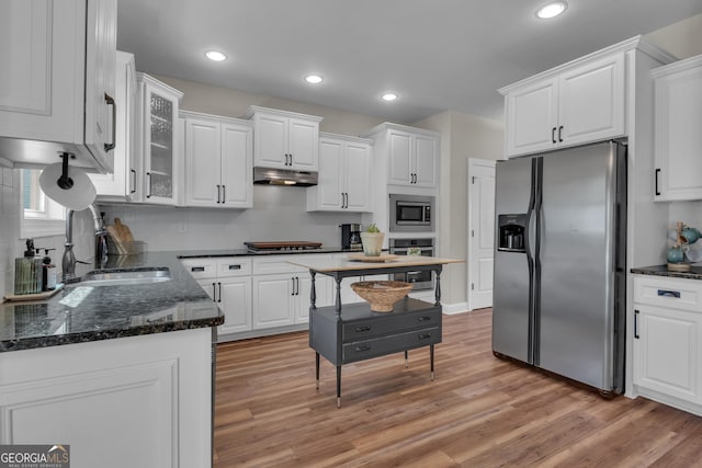 kitchen featuring under cabinet range hood, white cabinetry, and stainless steel appliances