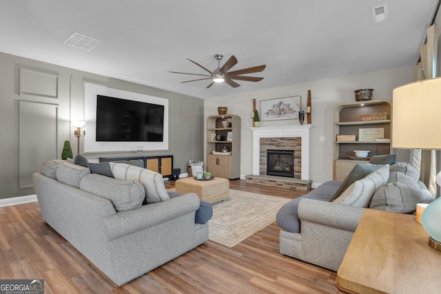 living area featuring a ceiling fan, visible vents, and light wood finished floors