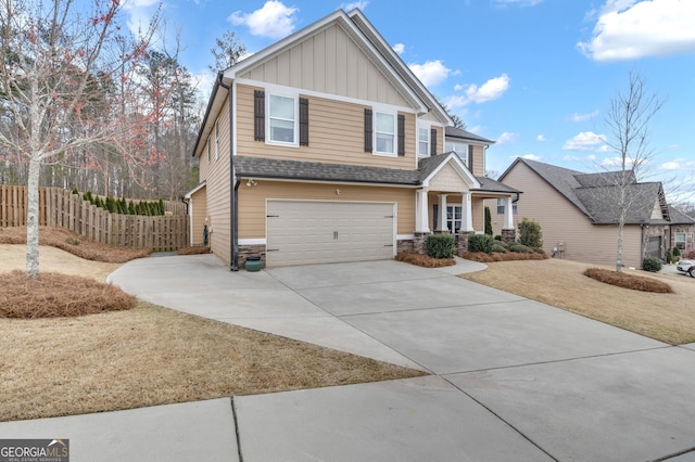 craftsman house with fence, driveway, a garage, stone siding, and board and batten siding