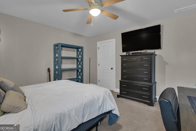 bedroom featuring baseboards, light colored carpet, visible vents, and ceiling fan