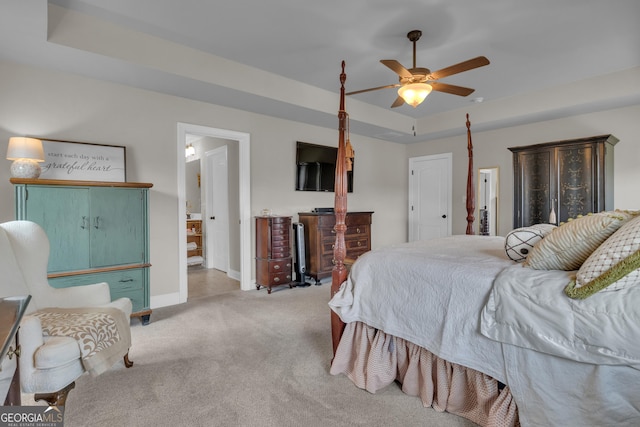 carpeted bedroom featuring a ceiling fan, a raised ceiling, and baseboards