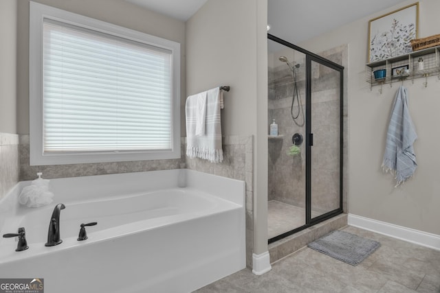 bathroom featuring a garden tub, baseboards, and a stall shower