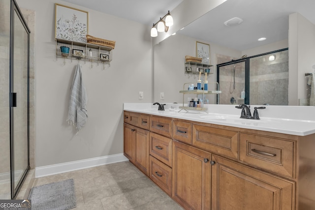 full bathroom featuring double vanity, baseboards, a stall shower, and a sink