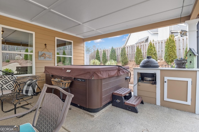 view of patio featuring a hot tub and fence