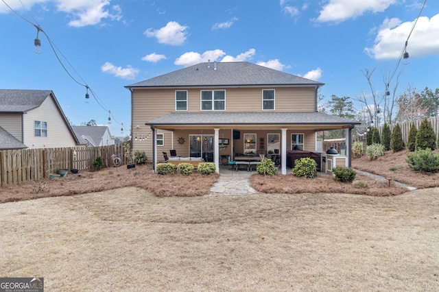 back of house with a patio area, an outdoor living space, a fenced backyard, and roof with shingles