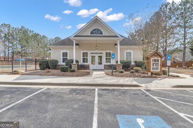 view of building exterior with uncovered parking and fence