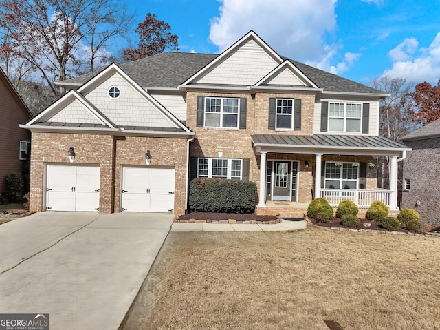 view of front of house with a standing seam roof, brick siding, covered porch, an attached garage, and concrete driveway