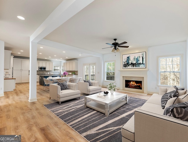 living area featuring light wood finished floors, recessed lighting, and a wealth of natural light