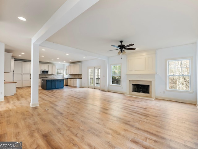 unfurnished living room featuring recessed lighting, light wood-style flooring, and a fireplace