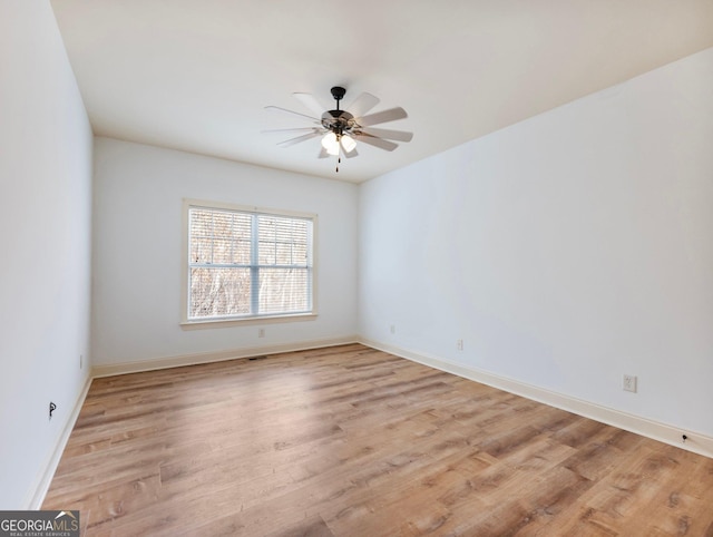 unfurnished room with a ceiling fan, light wood-style floors, and baseboards