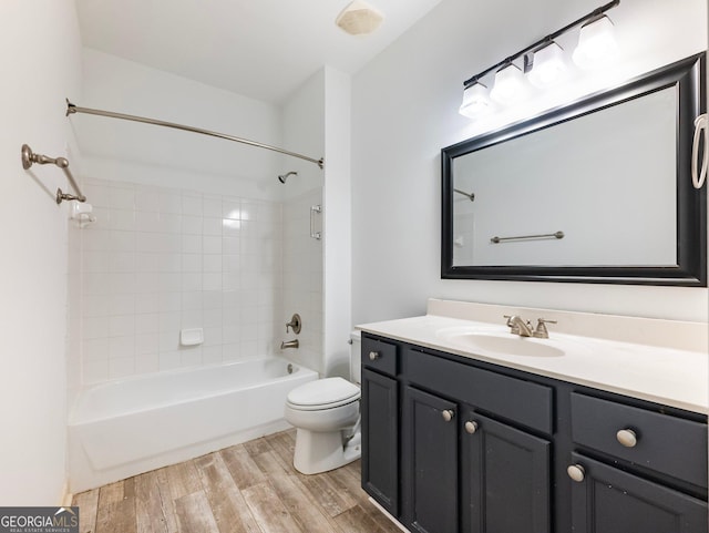 bathroom featuring bathing tub / shower combination, toilet, wood finished floors, and vanity