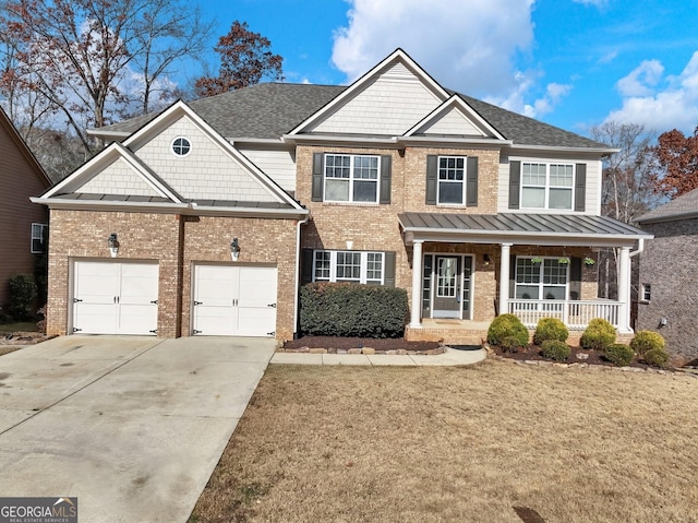 craftsman-style home with brick siding, concrete driveway, a front yard, covered porch, and a standing seam roof