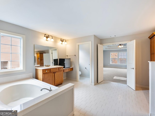 full bathroom featuring visible vents, baseboards, toilet, a garden tub, and vanity