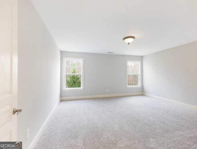 unfurnished room featuring visible vents, baseboards, and carpet