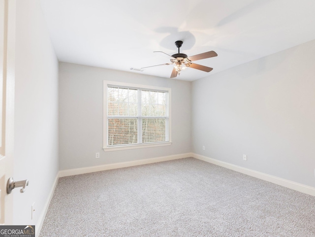 empty room featuring ceiling fan, carpet, visible vents, and baseboards