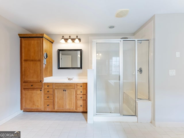full bathroom featuring tile patterned floors, vanity, baseboards, and a stall shower