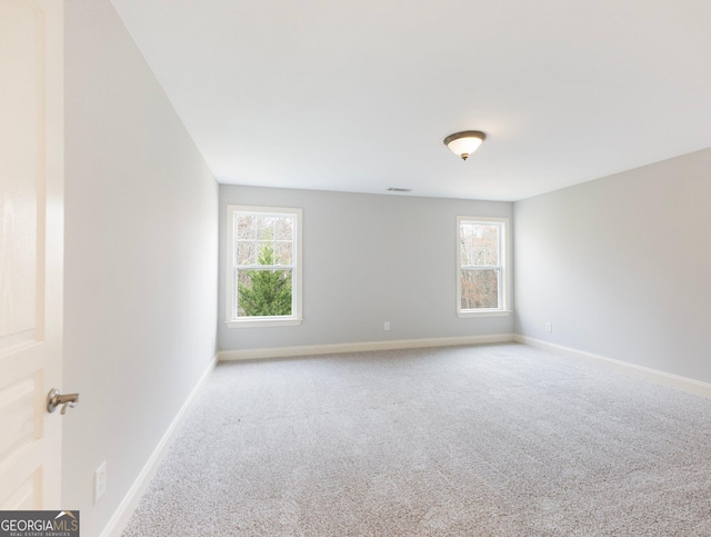 carpeted spare room featuring baseboards