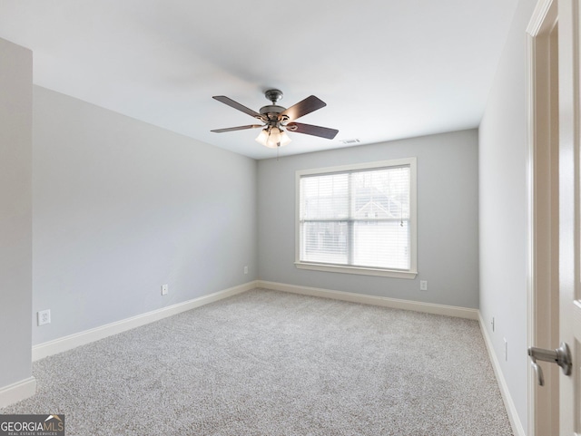 carpeted spare room with ceiling fan, baseboards, and visible vents