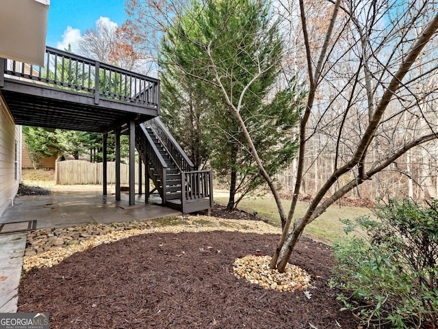 view of yard with a deck, stairway, a patio, and fence