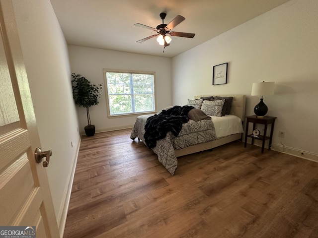 bedroom with baseboards, a ceiling fan, and wood finished floors