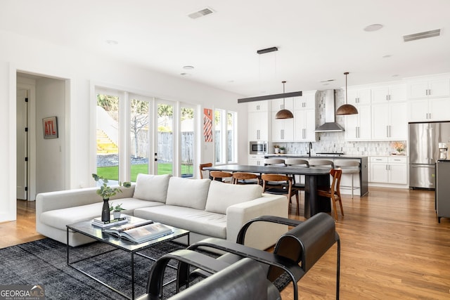 living room featuring visible vents and light wood finished floors