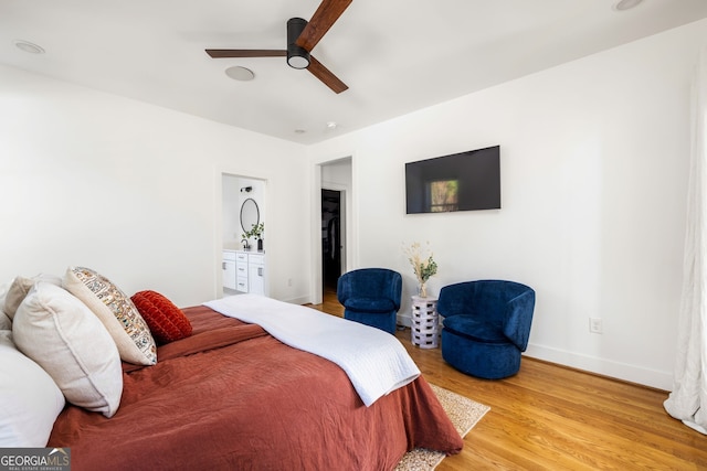 bedroom featuring wood finished floors, baseboards, ensuite bathroom, and ceiling fan