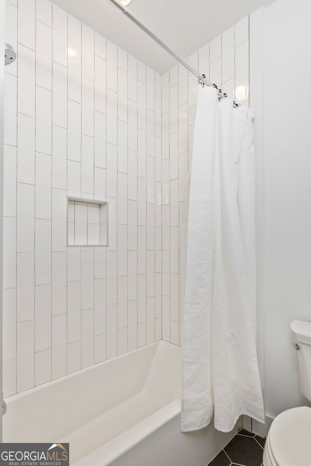 bathroom with toilet, shower / tub combo, and tile patterned flooring