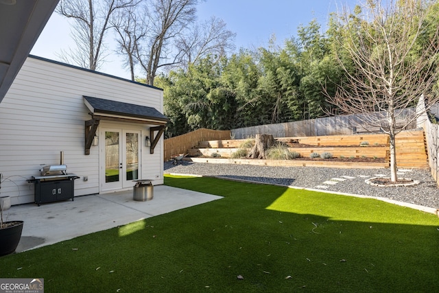 view of yard with a fenced backyard, french doors, and a patio