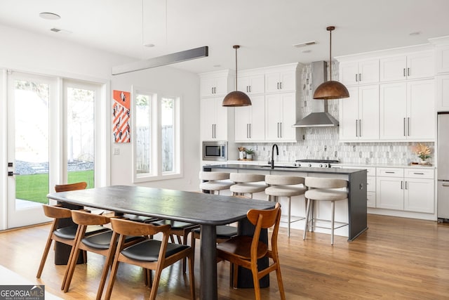 dining room with a wealth of natural light, visible vents, and light wood-type flooring