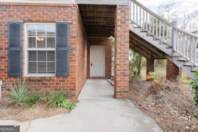 entrance to property featuring brick siding