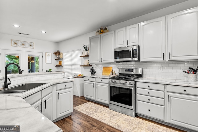 kitchen featuring visible vents, dark wood-style flooring, a sink, stainless steel appliances, and white cabinets