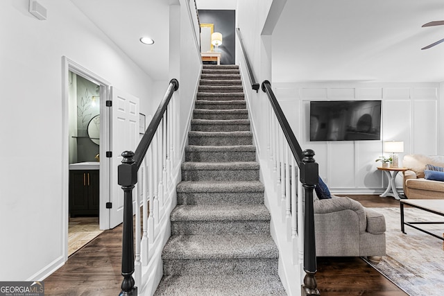 stairs featuring a decorative wall, recessed lighting, ceiling fan, and wood finished floors