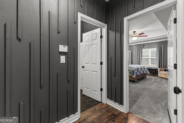 corridor with dark wood-style floors and dark carpet