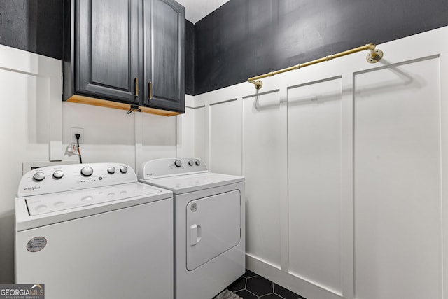 laundry area with cabinet space, dark tile patterned floors, and washer and clothes dryer