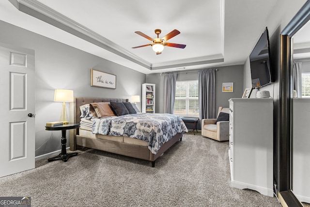 bedroom featuring a raised ceiling, carpet flooring, baseboards, and ornamental molding