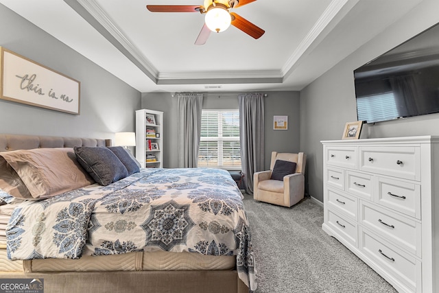 bedroom with a tray ceiling, light carpet, ceiling fan, and crown molding