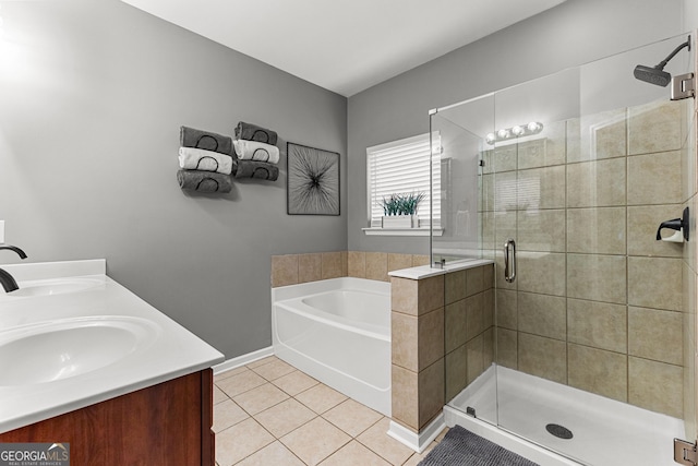 bathroom featuring tile patterned floors, a stall shower, a garden tub, and a sink