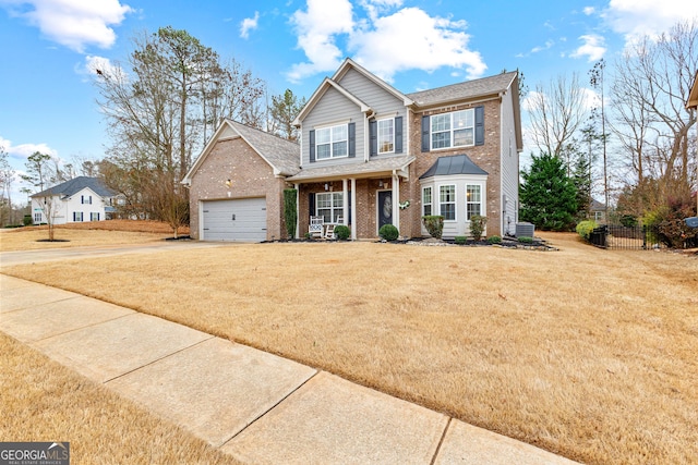 view of front of property featuring fence, concrete driveway, a front lawn, a garage, and brick siding