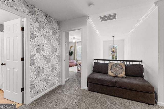 hallway with baseboards, visible vents, ornamental molding, carpet flooring, and a chandelier