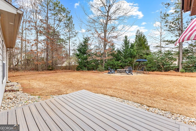 deck featuring a patio area, a fire pit, and a lawn