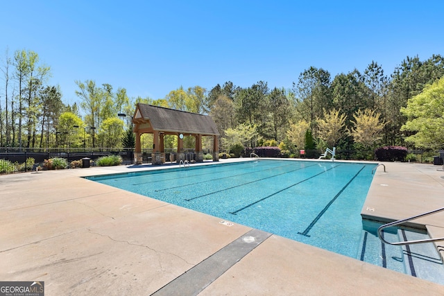 community pool with a gazebo, a patio area, and fence