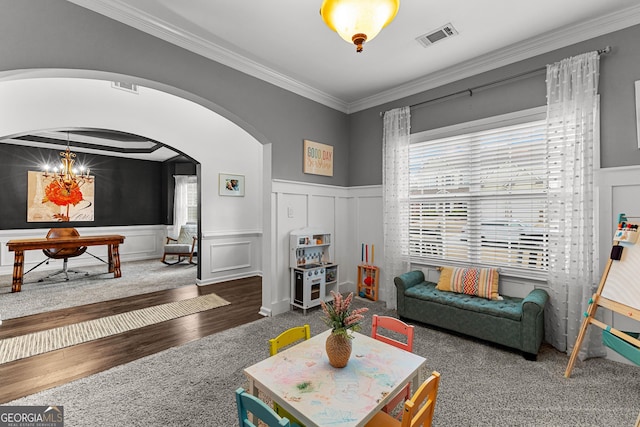 living room with visible vents, ornamental molding, an inviting chandelier, arched walkways, and a decorative wall