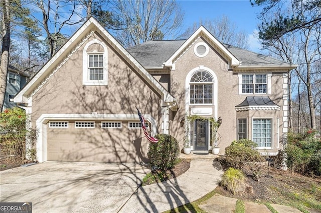 217 Colonial Dr, Woodstock, GA 30189 - view of front facade with driveway, an attached garage, and stucco siding