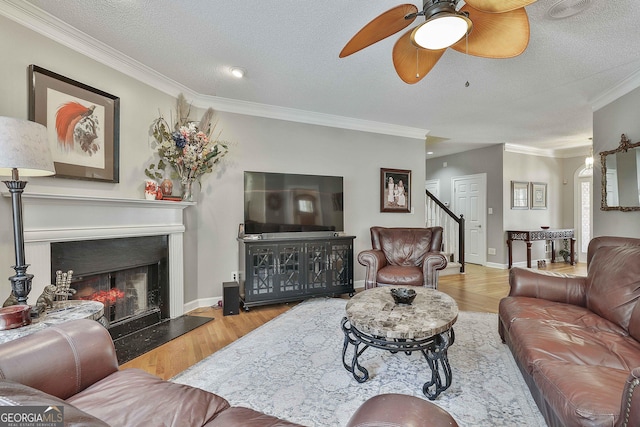 living room featuring a warm lit fireplace, crown molding, and wood finished floors